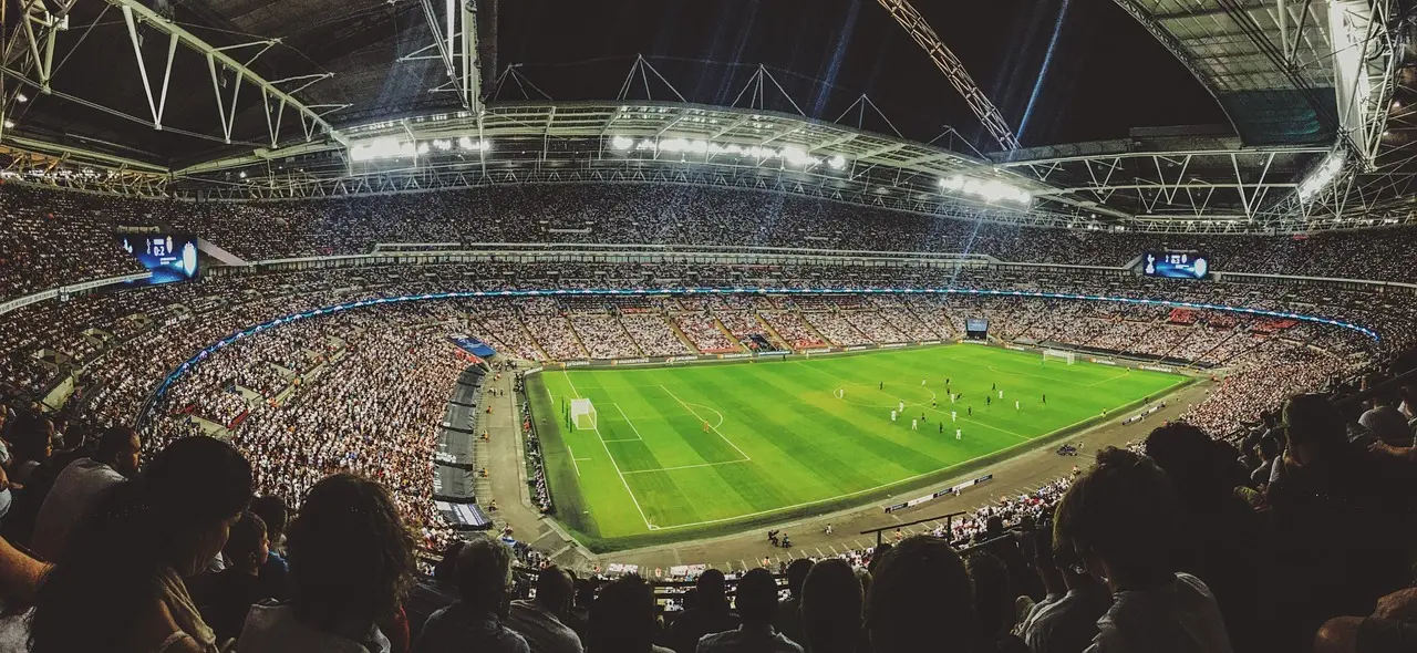En fotbollsmatch på en arena med fullsatta läktare